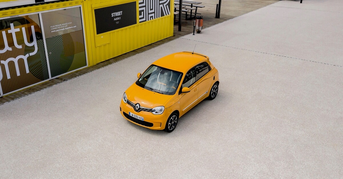 Oranje Renault Twingo naast container