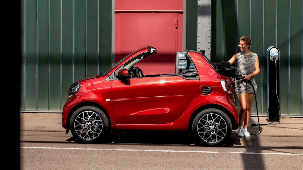 vrouw laadt elektrische cabrio